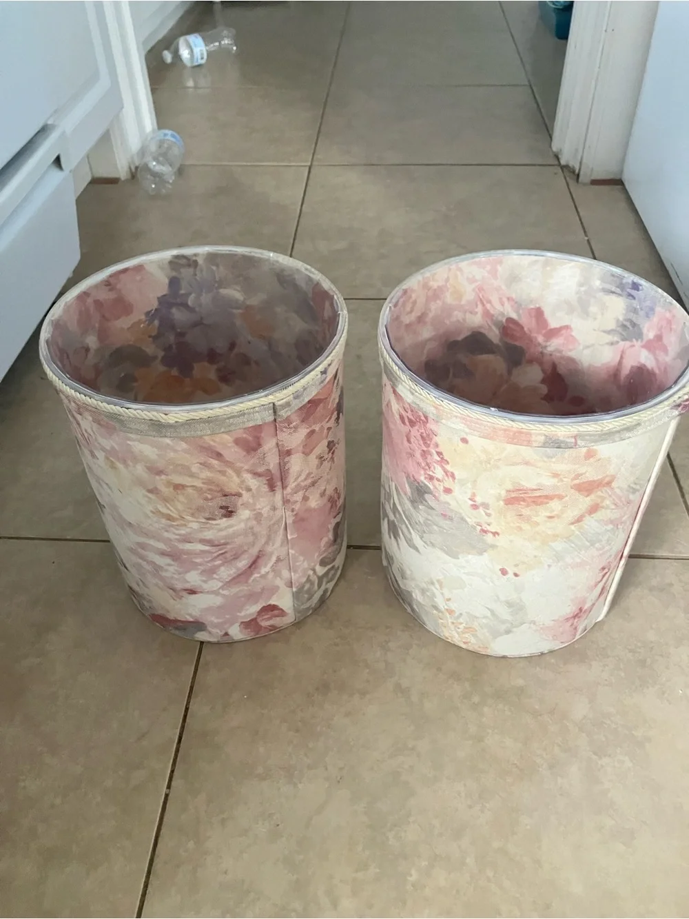 2 vintage floral tapestry fabric wastebaskets with plastic liners in them